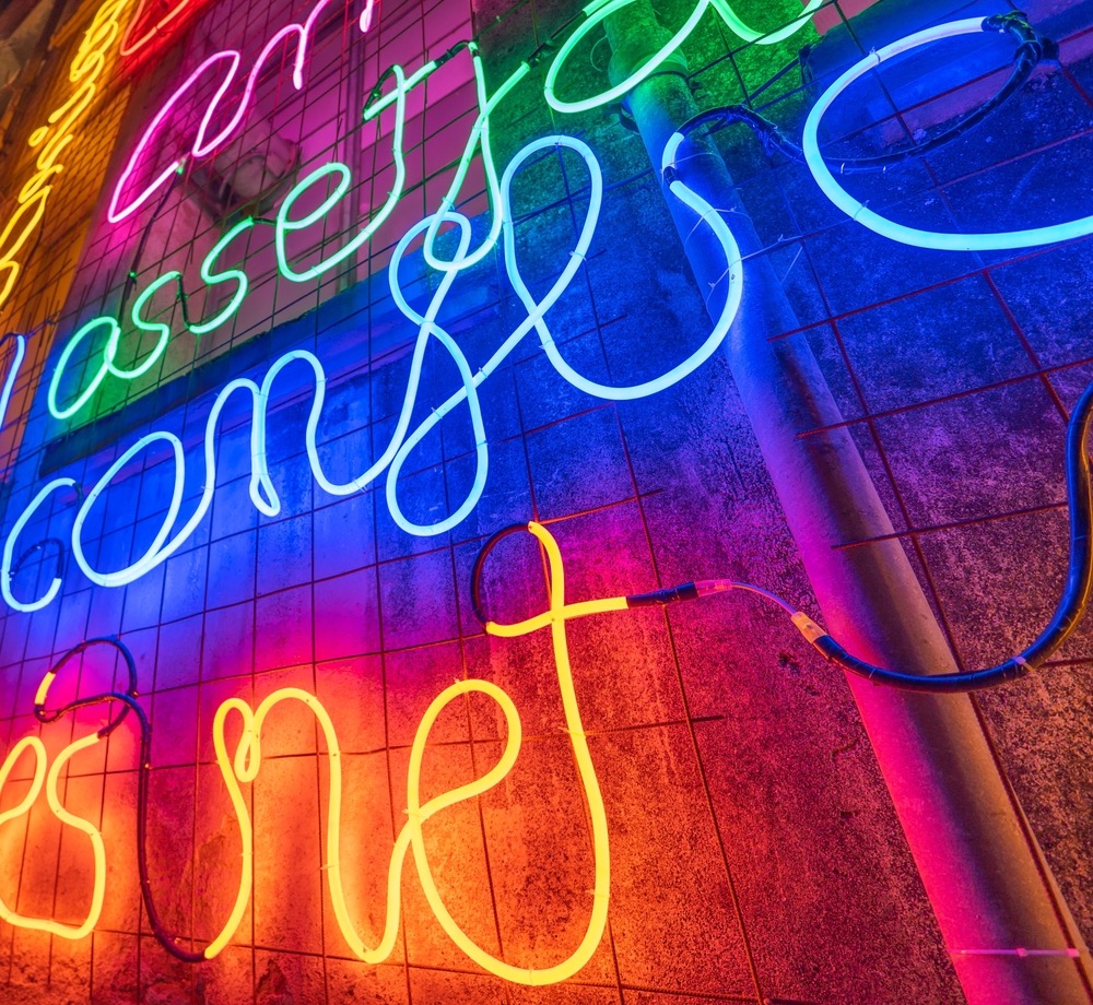 Illuminated,Letters,And,Words,Made,With,Neon,Lights,And,Leds Illuminated letters and words made with neon lights and LEDs of many colors with words in the Catalan language with evocative concepts of hope and wishes on a wall. Low angle view.