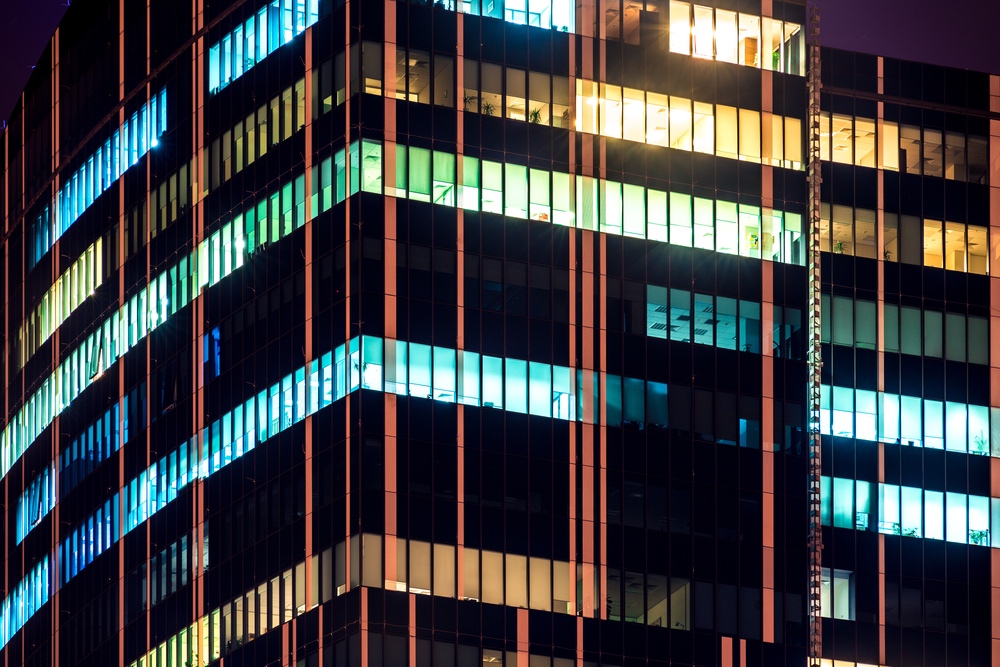 Skyscrapers,Modern,Office,Building,With,Glowing,Windows,At,Night Skyscrapers modern office building with glowing windows at night